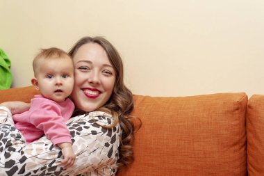 Küçük bir bebekle mutlu bir genç kadının portresi..