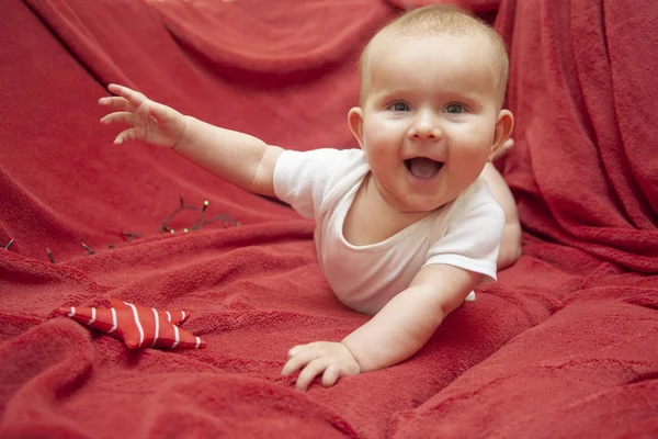 Infant baby on a red rug — Stock Photo, Image