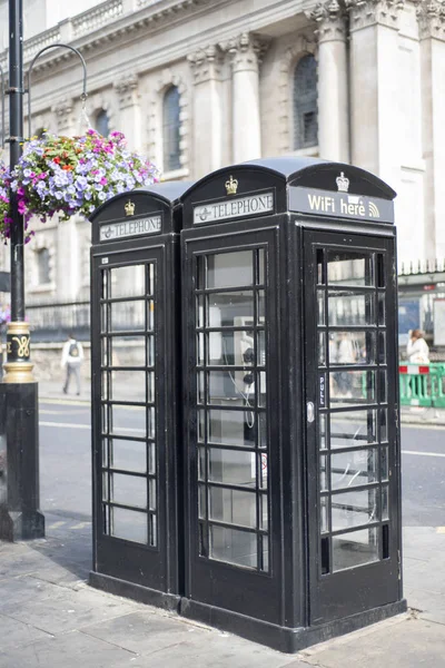 Two black (not red) London telephone boxes. Slightly unusual and strict colour.