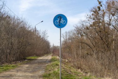 Ormanda eski bir bisiklet yolu ve bozuk bir bisiklet yolu tabelası..
