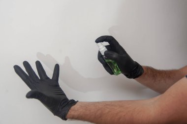 Dezenfektanla el dezenfeksiyonu. Siyah nitril eldivenli insanlar..