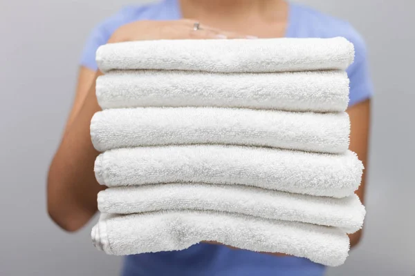 Dienstmädchen mit einem Stapel weißer, frischer Handtücher — Stockfoto