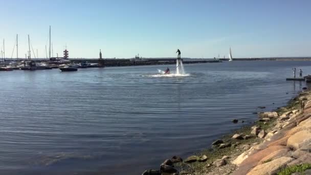 ヨット ハーバーで Flyboard に水の上に立っている男性 スポーツ — ストック動画
