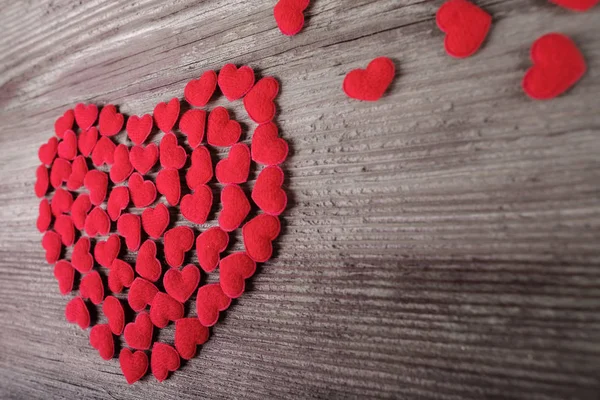 Gruppo di piccoli simboli del cuore rosso su sfondo di legno — Foto Stock