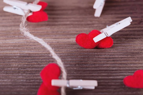 Red textile hearts connected by clothespin. Love concept. — Stock Photo, Image