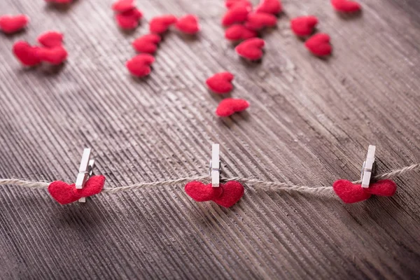 Corazones textiles rojos conectados por pinza de ropa. Concepto de amor — Foto de Stock