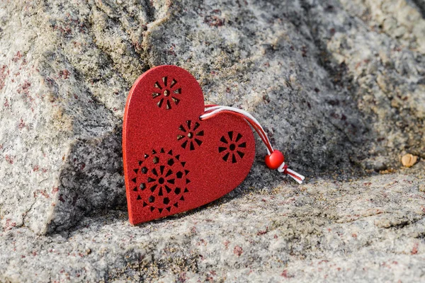 Rotes hölzernes Herzsimbol auf Stein liegend. — Stockfoto