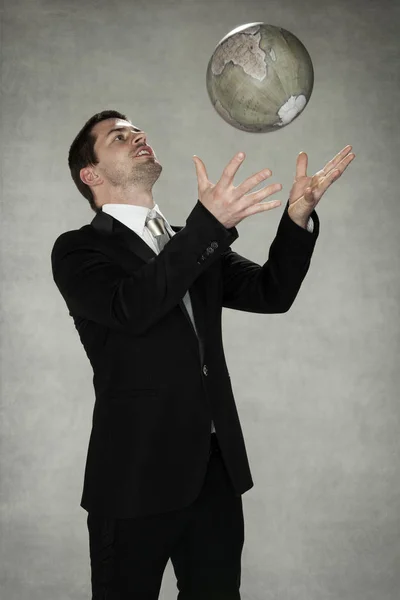 Homem de negócios brincando com o mundo — Fotografia de Stock