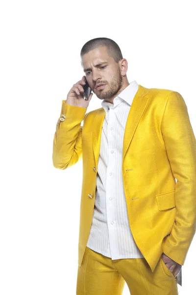 business man in gold suit talks on the phone