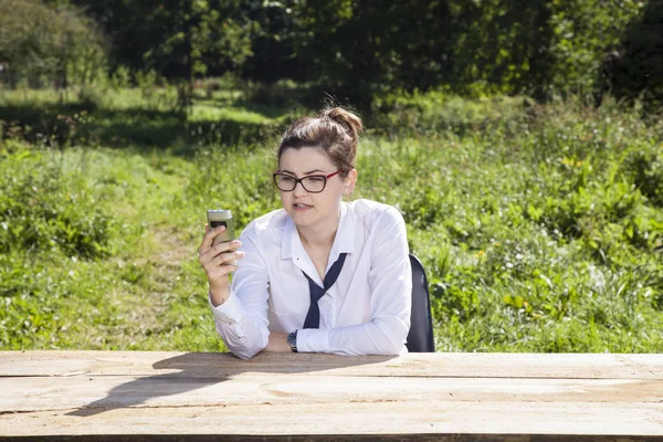 Mujer de negocios comprueba su teléfono móvil — Foto de Stock