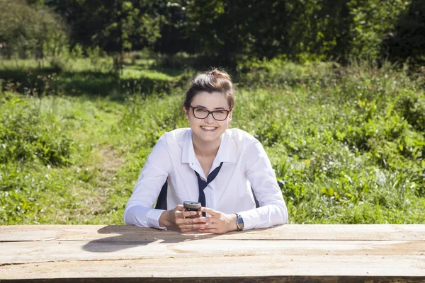 Glimlachende zakenvrouw bedrijf van de telefoon in haar handen — Stockfoto