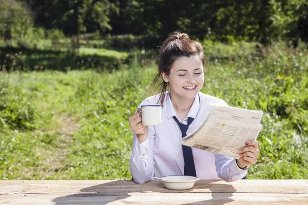 Mujer de negocios leyendo un periódico mientras bebe café —  Fotos de Stock