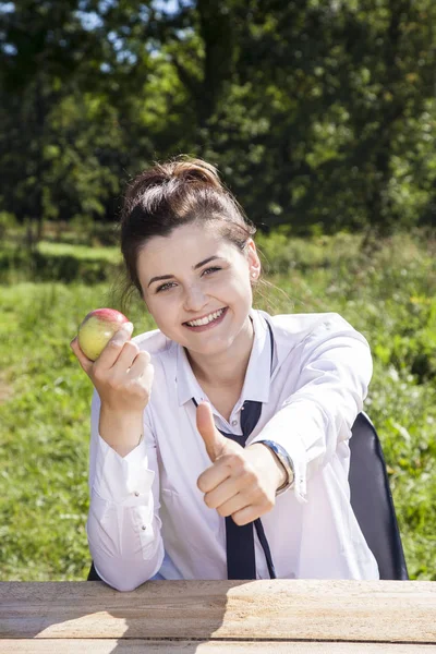 Obchodní žena jíst jablko, palec nahoru — Stock fotografie