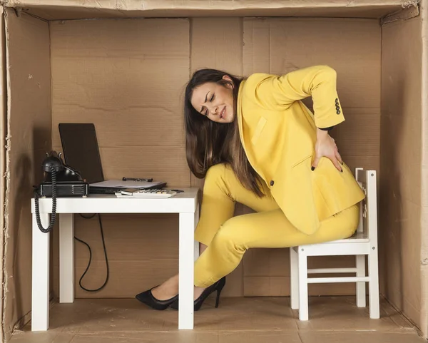 Jeune femme d'affaires a mal au dos d'une mauvaise chaise de bureau — Photo