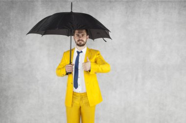 Gülümseyen sigorta acentası başparmak yukarı doğru gösterir