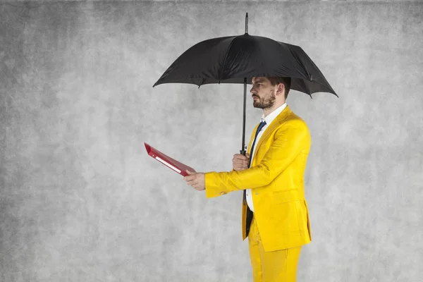 Geschäftsmann unter dem Schirm gibt Aktenkoffer — Stockfoto