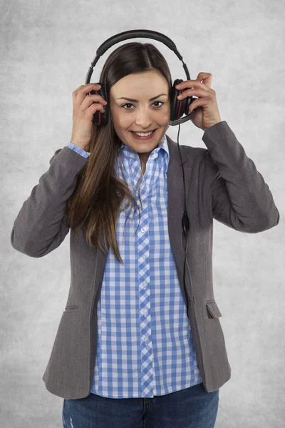 Happy woman puts earphones on her ears — Stock Photo, Image