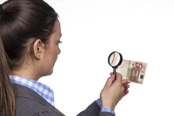 Jovem empresária verifica a autenticidade do dinheiro em branco b — Fotografia de Stock