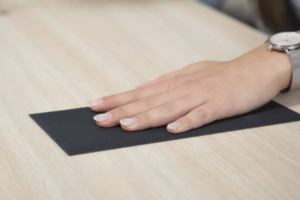 Hand auf schwarzem Umschlag, Bestechungsgeld auf dem Schreibtisch — Stockfoto