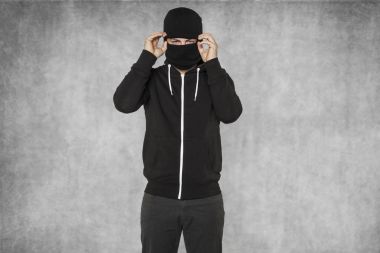 Maskeli bir adam yüzünü kapsar