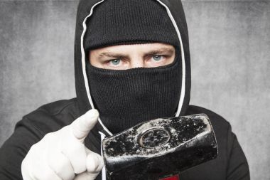 Maskeli yabancı bir çekiç kameraya gösterir ve seni işaret ediyor