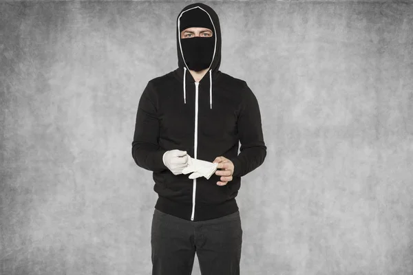 Masked man removes gloves — Stock Photo, Image