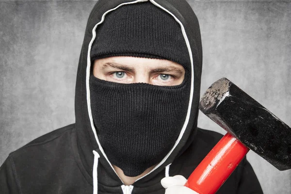 Primer plano de un extraño enmascarado, martillo en una mano — Foto de Stock