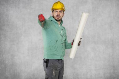 İşçi planları elinde tutar, başparmak aşağı