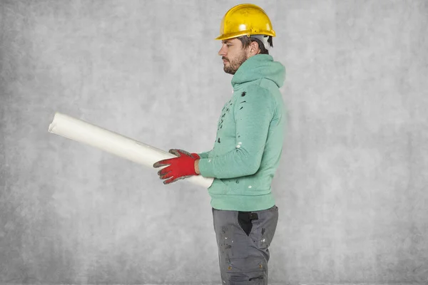 Um trabalhador sério com planos de construção na mão, espaço de cópia — Fotografia de Stock