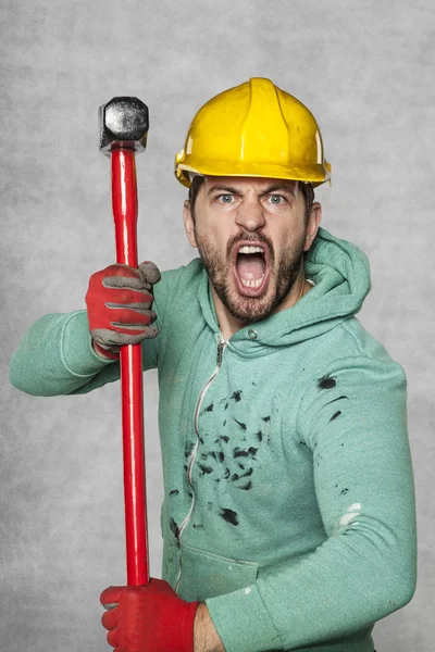 De werknemer met een grote hamer schreeuwt als een gek — Stockfoto