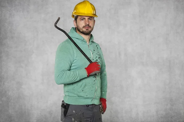 Worker holding a crowbar in his hand — Stock Photo, Image