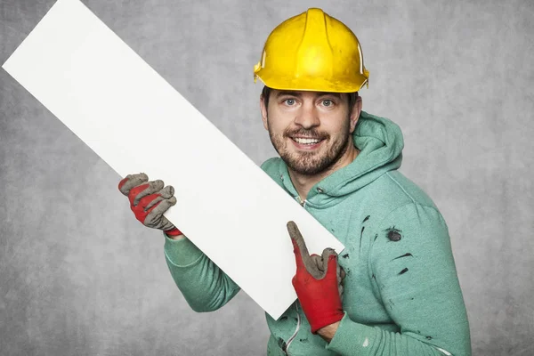 The worker holds a blank billboard, a place for advertising — Stock Photo, Image