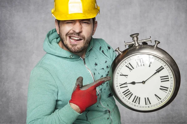 El trabajador guarda el reloj y lo indica —  Fotos de Stock