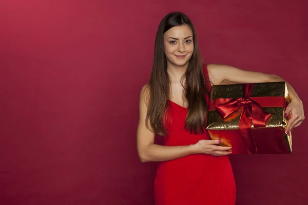 Menina bonita está segurando um presente bem embrulhado — Fotografia de Stock