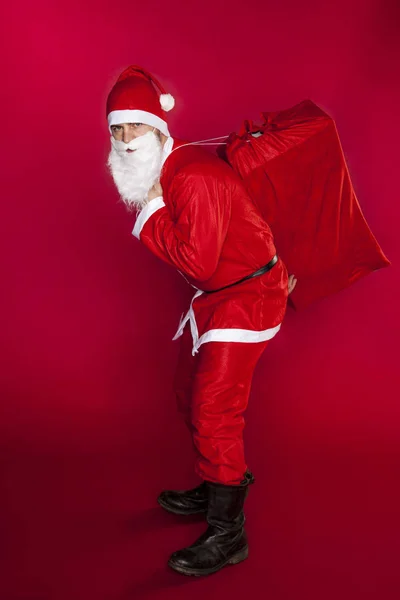 Santa Claus is het dragen van een grote zak van giften — Stockfoto