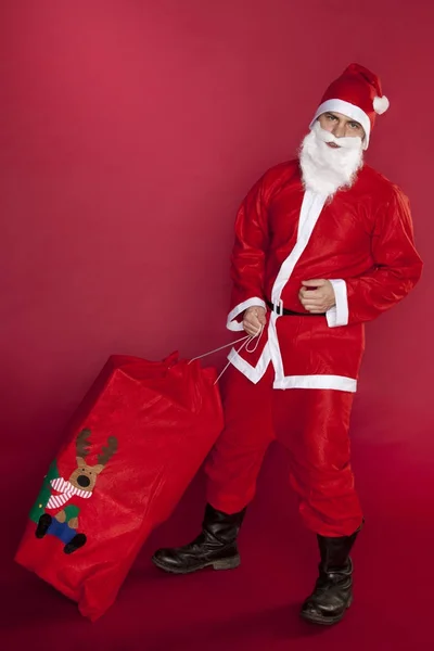 Злой Санта-Клаус вытаскивает свою сумку с подарками — стоковое фото
