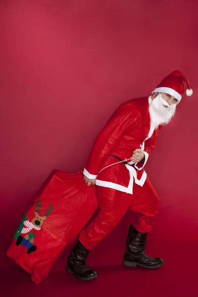 Разочарованный Санта Клаус вытаскивает сумку с подарками — стоковое фото