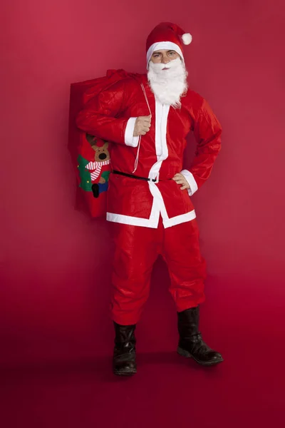 Koele Santa Claus stands met een zak vol cadeaus — Stockfoto