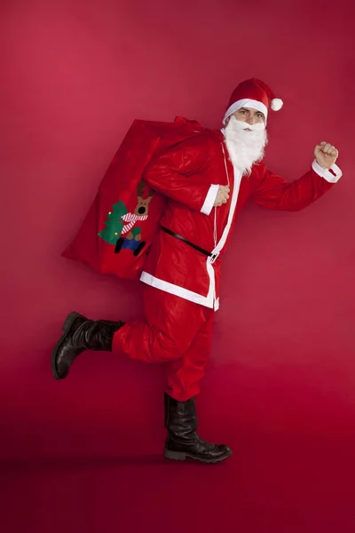 Santa Claus corre con bolsa de regalos — Foto de Stock