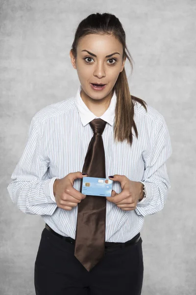 Verbaasd zakenvrouw met een credit card bedrijf in haar handen — Stockfoto