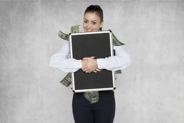 Mujer de negocios aprieta una maleta llena de dinero —  Fotos de Stock