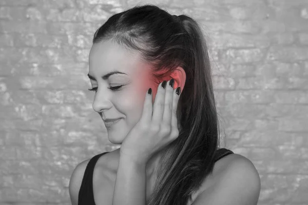 Mladá žena bojuje s uchem drumache — Stock fotografie