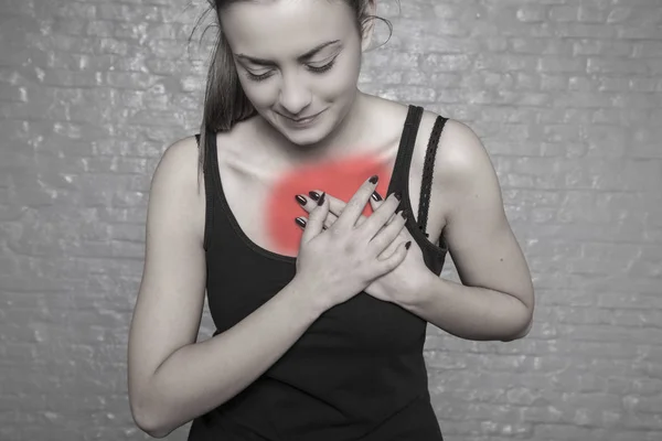 Una mujer joven sostiene su pecho, Posible ataque al corazón, primero —  Fotos de Stock