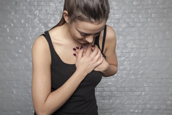 Uma jovem está segurando seu peito, possível ataque cardíaco ou dente — Fotografia de Stock