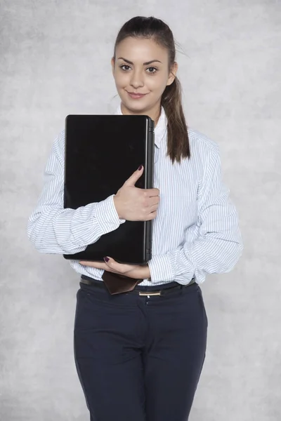 Mulher de negócios segurando um laptop em seus braços — Fotografia de Stock