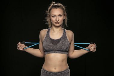 atletik bir kadın elastik kauçuk onun arkasında uzanır.