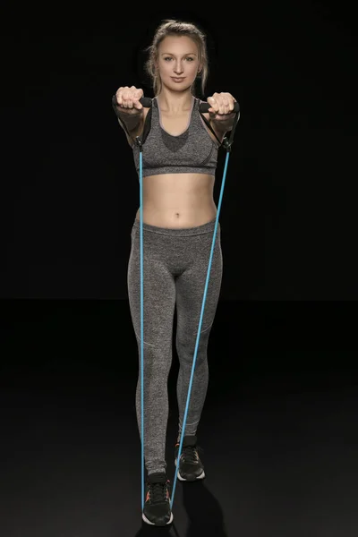 Atletisk flicka sträcker sig och övningar med ett flexibelt rep — Stockfoto