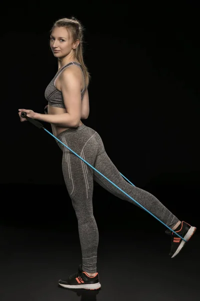 Atletisk flicka sträcker sig och övningar med ett flexibelt rep — Stockfoto