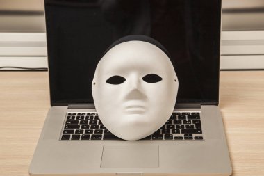 Kavramsal fotoğraf, maske bir hacker attac bir sembolü olarak bir dizüstü bilgisayar