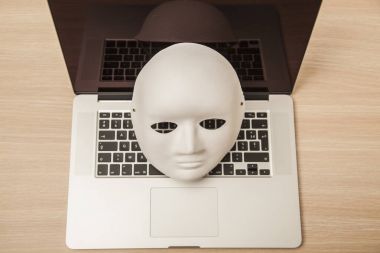 Kavramsal fotoğraf, maske bir hacker attac bir sembolü olarak bir dizüstü bilgisayar